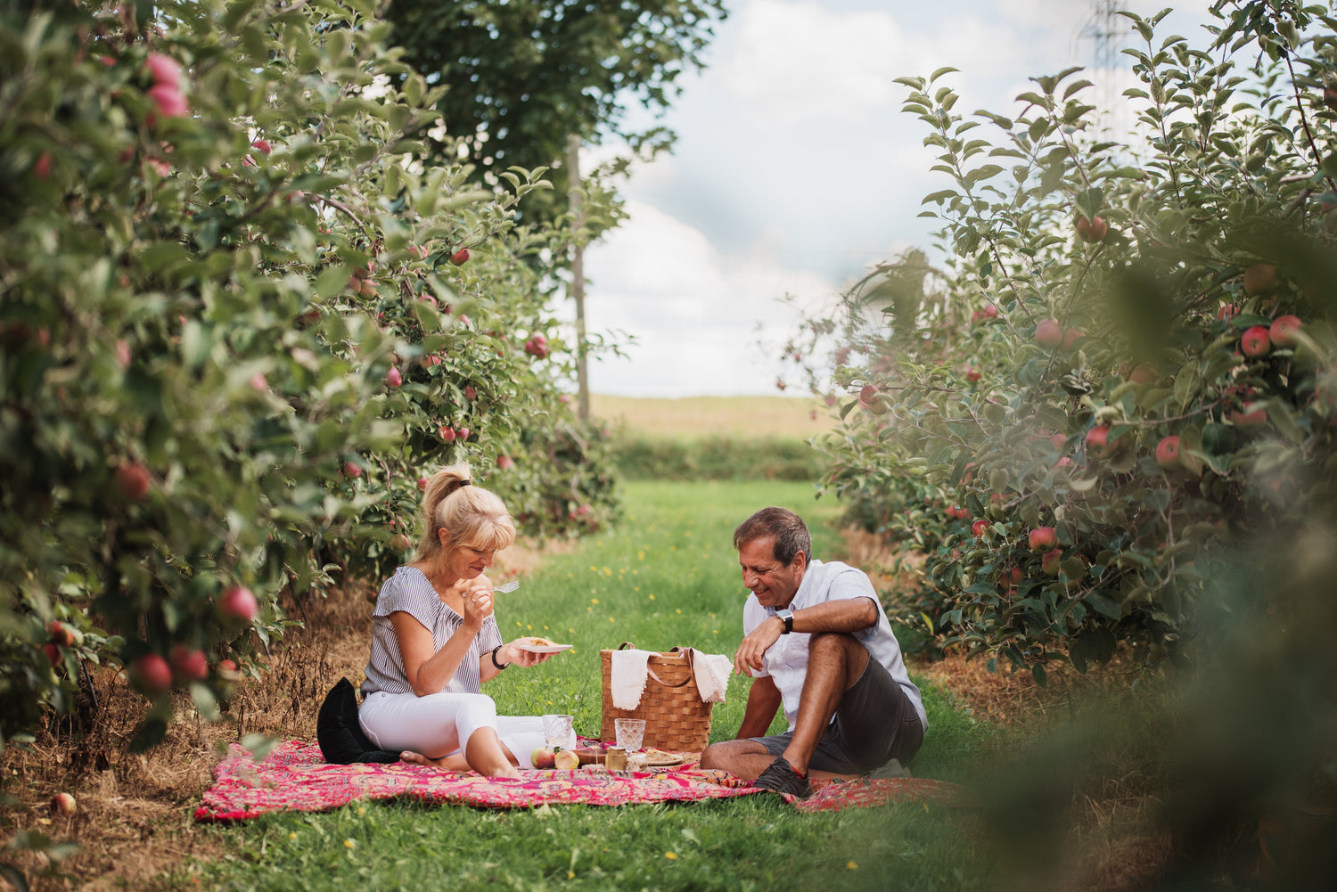 couple-assis-sur-de-lherbe-au-verger